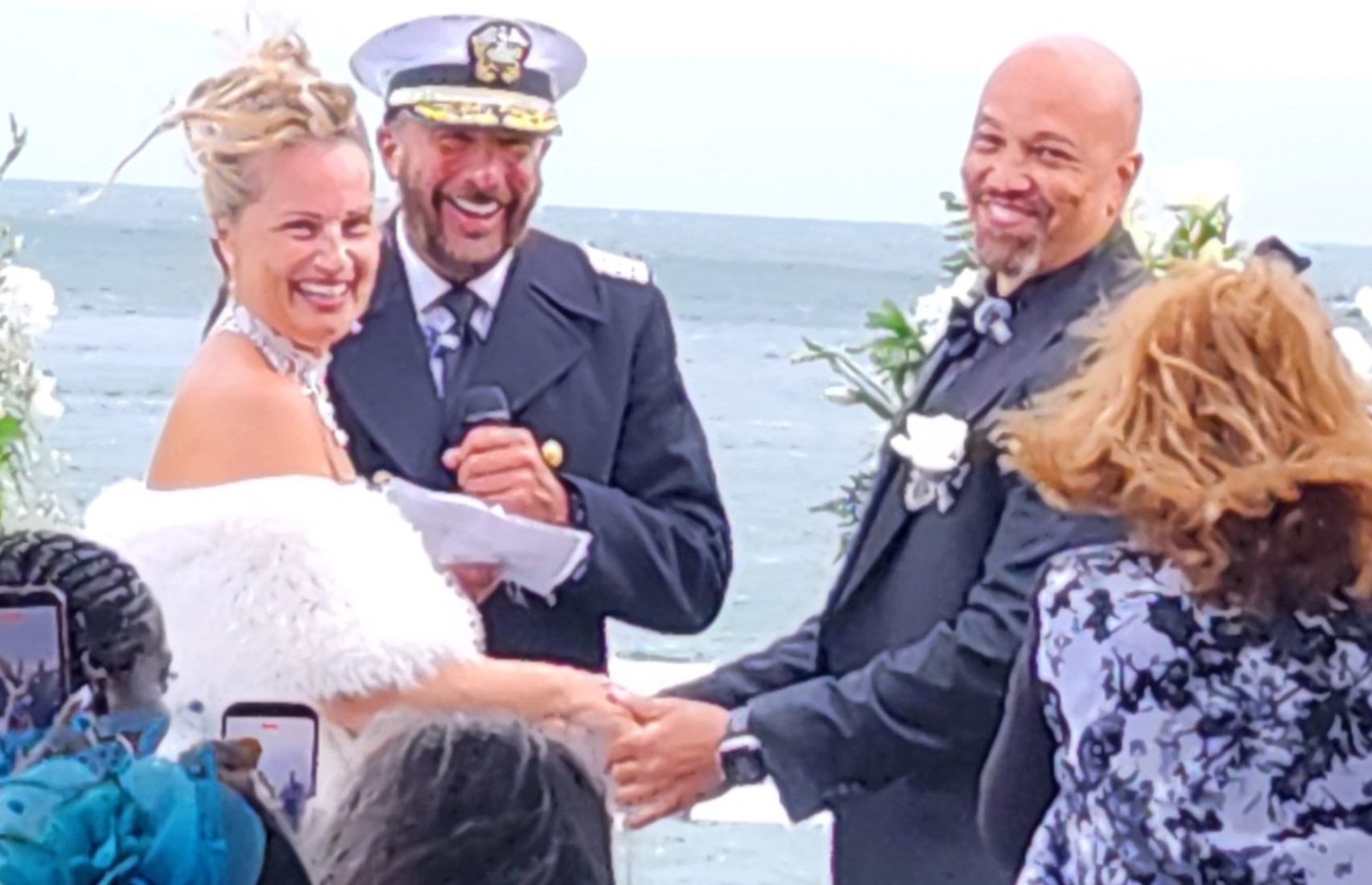 Captain Arlan sharing a laugh with a couple during their wedding ceremony on the water